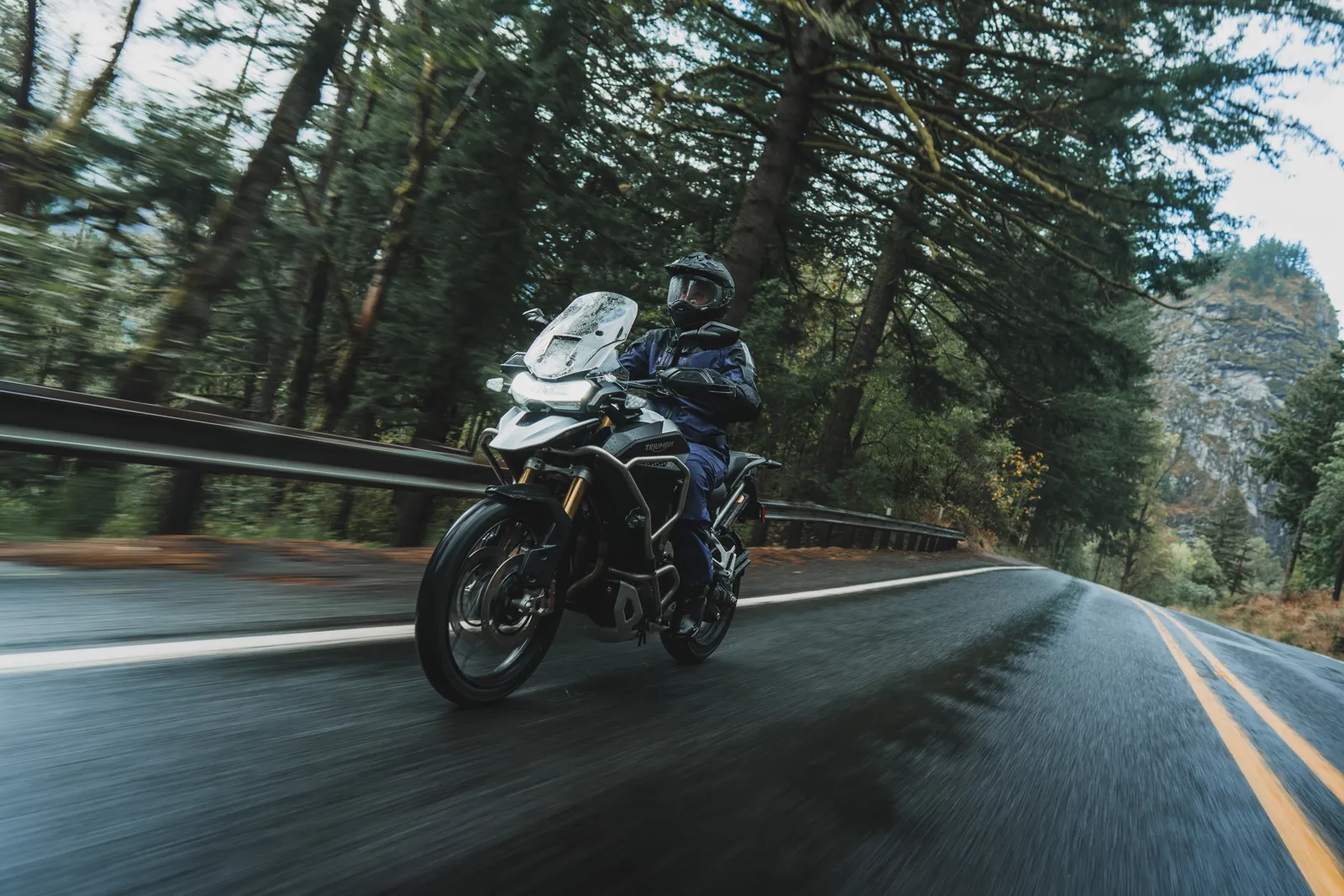 Motociclist în echipament touring pe drum umed