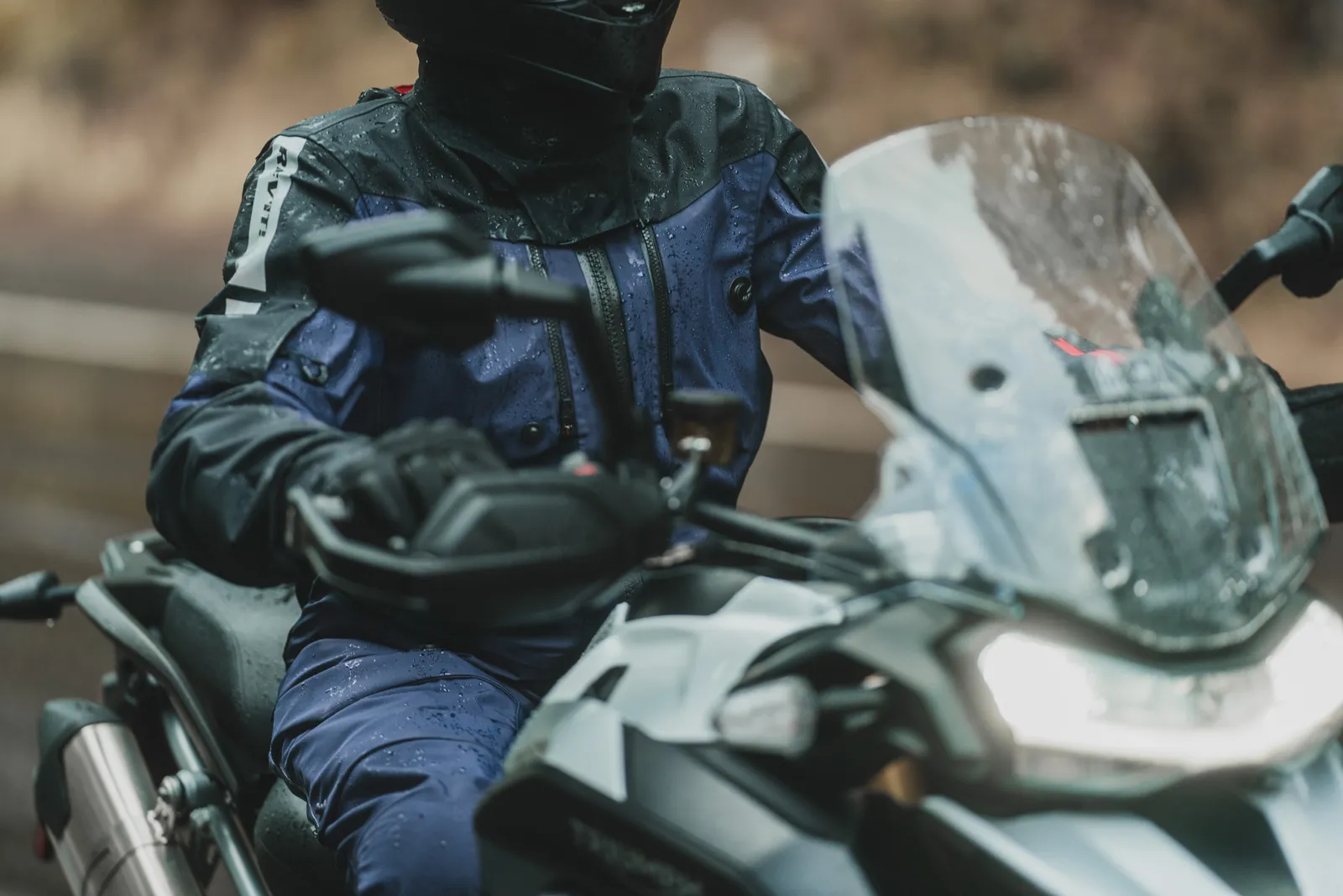 Rider în geacă touring pe motocicletă în ploaie