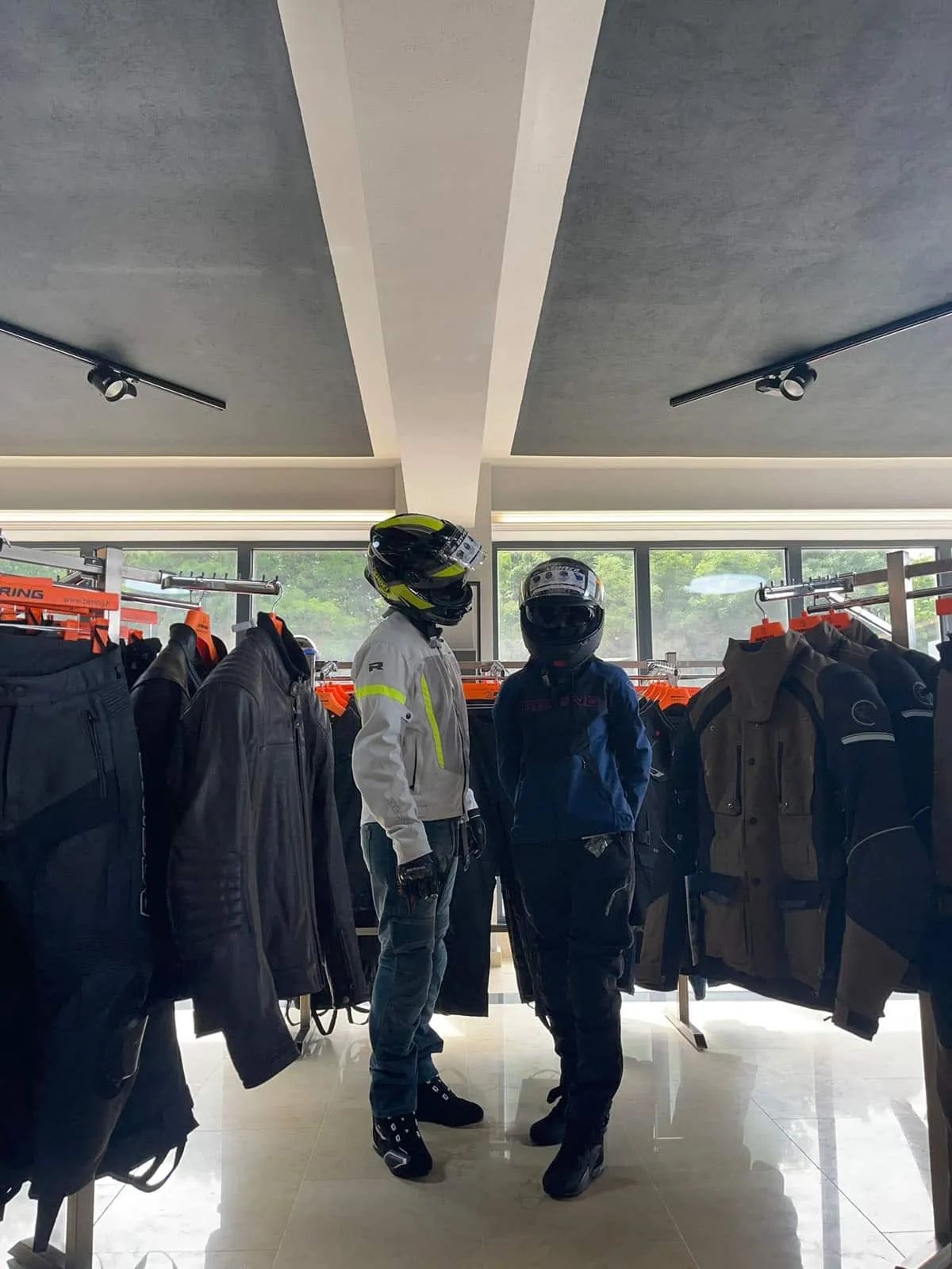 Rideri echipați cu geci moto de vară în showroom BBMoto