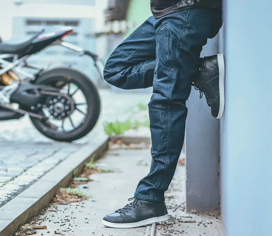 Rider cu blugi moto TRILOBITE lângă motocicletă, imagine outdoor pentru echipament moto de început
