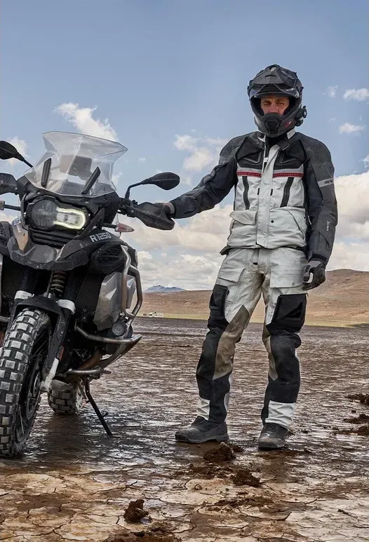 Motocicletă adventure cu bare de protecție și rider în teren