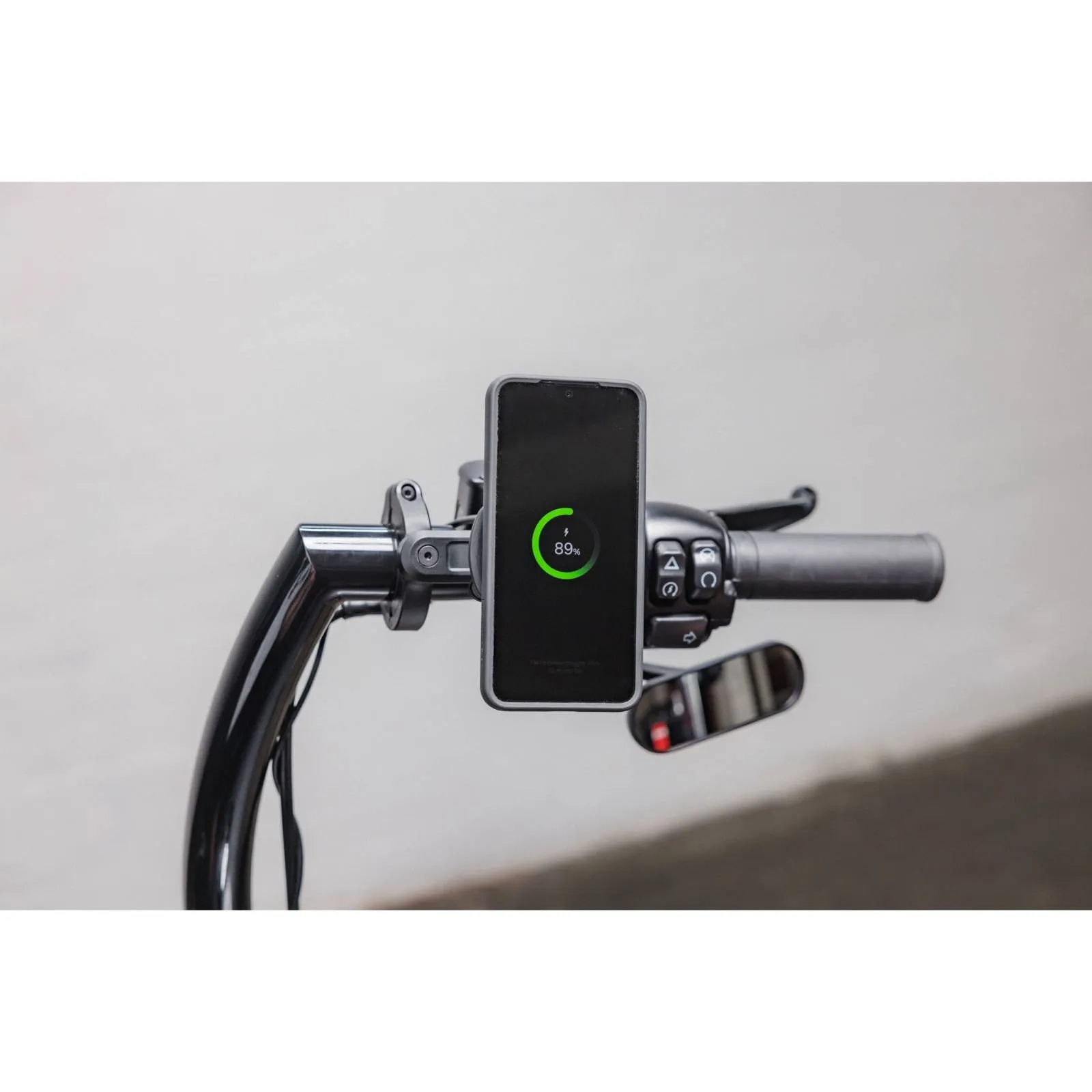Quad Lock wireless charging head montat pe ghidonul unei motociclete, cu telefonul la încărcat
