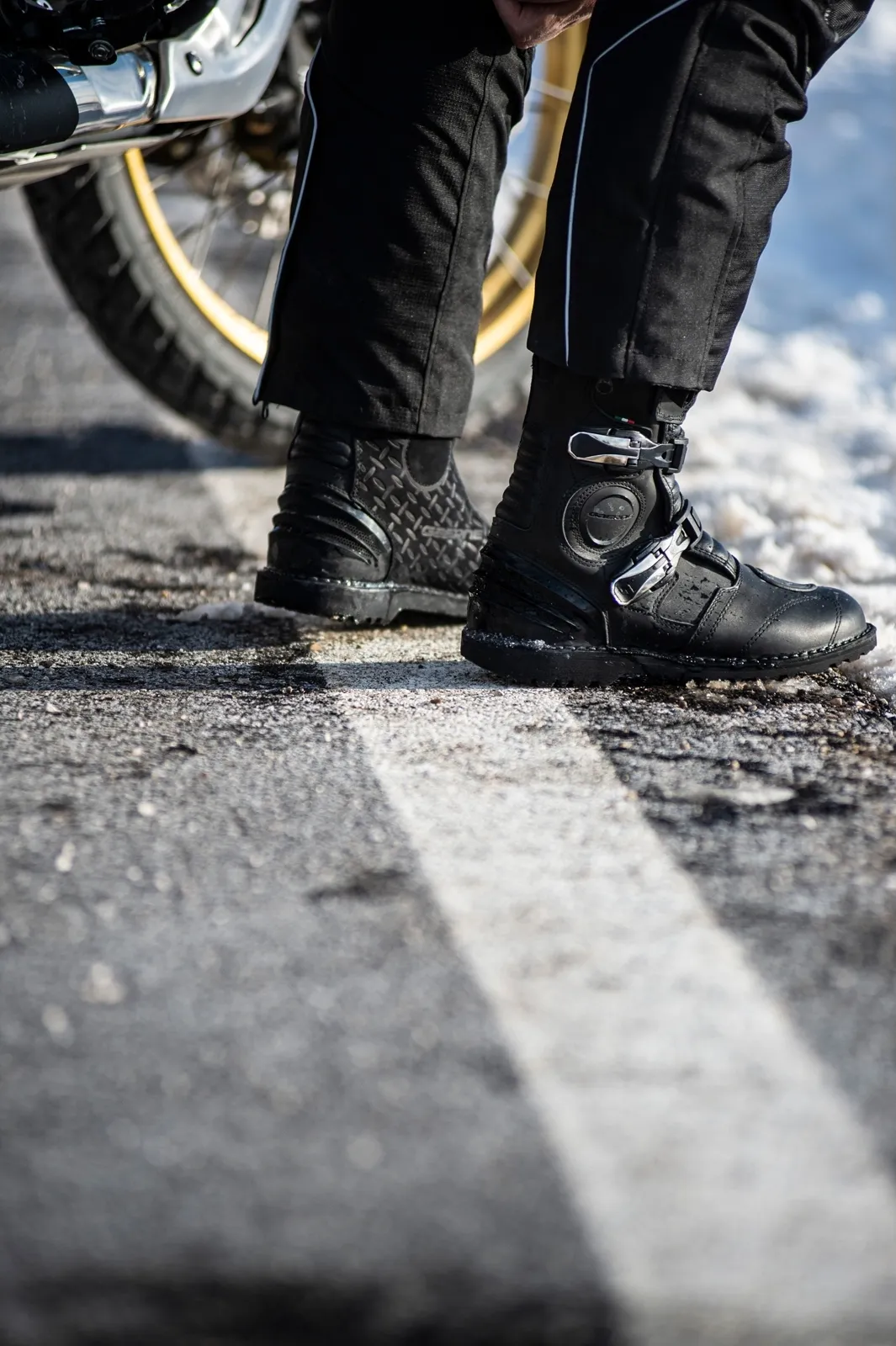 Cizme Gaerne G-Midland lângă motocicletă, pe carosabil ud