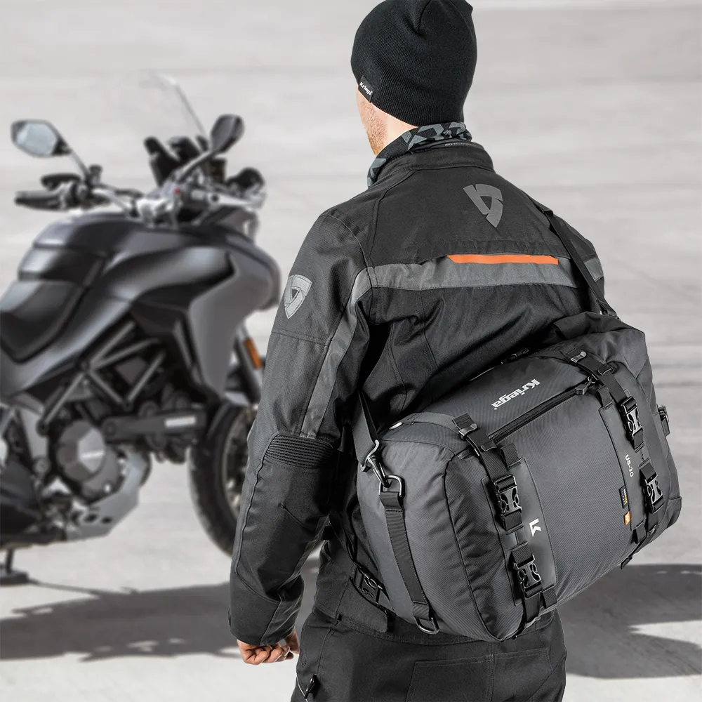 Drybag Kriega US-30 purtat de rider lângă motocicletă într-un cadru outdoor real