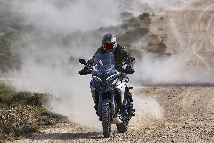 Motocicletă adventure pe drum de pământ, cu anvelopele în fundal real